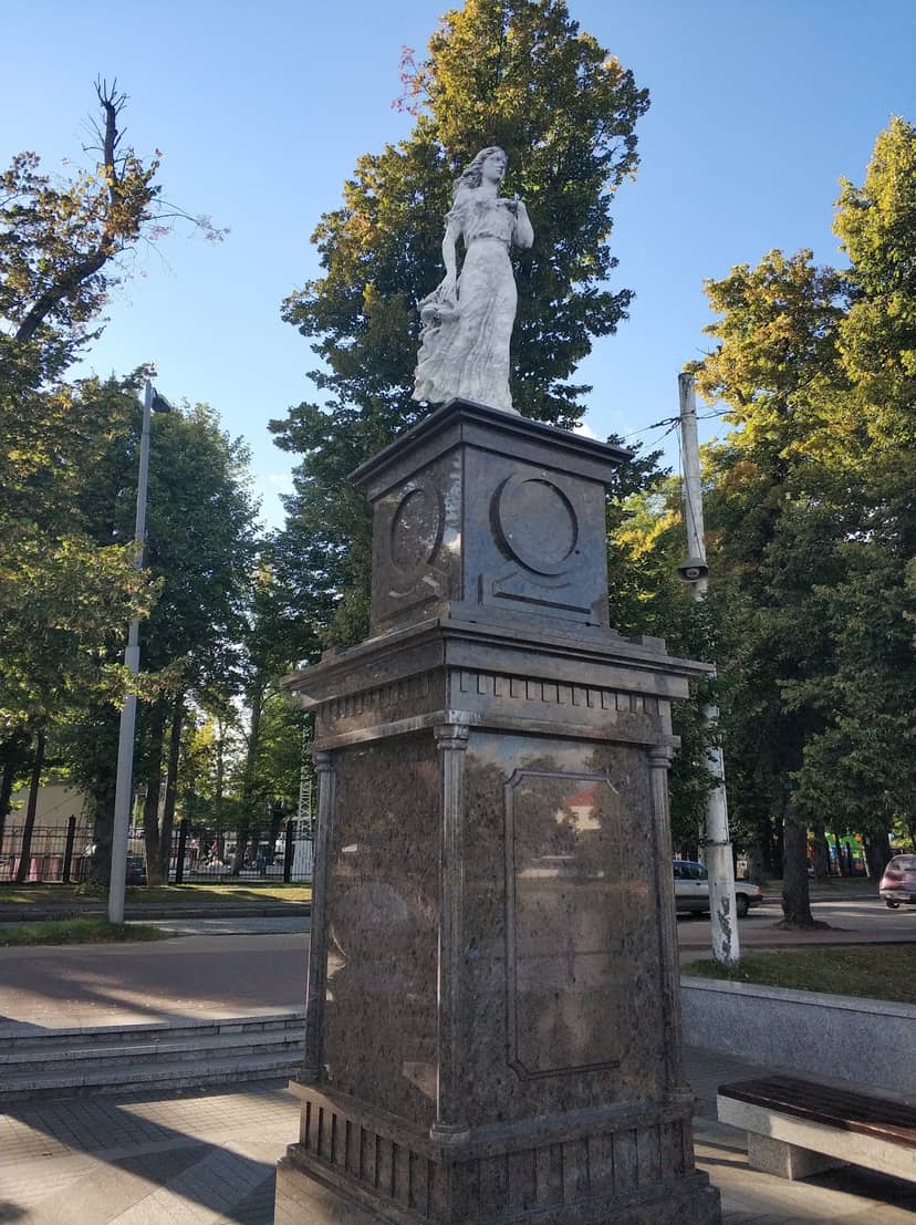 Женская скульптура на постаменте с часами